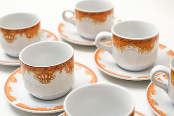 Elegant porcelain tea cups and saucers adorned with intricate gold crown designs, perfect for refined afternoon tea