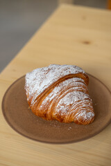Croissant served on plate, on the wooden table
