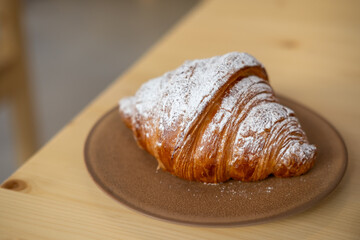 Croissant served on plate, on the wooden table
