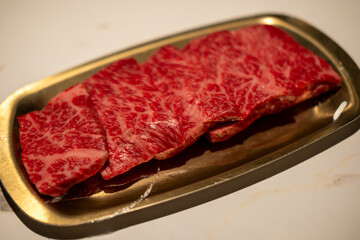 Raw Sliced Hanwoo Beef, marbled Korean Style Meat prepared on the golden plate