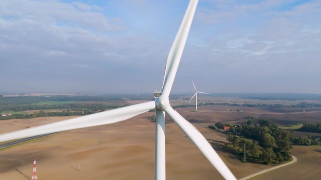 Aerial View of Spinning Wind Turbine Generating Renewable Energy in Countryside