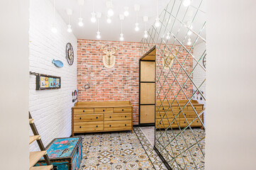 Eclectic interior featuring brick walls, patterned tile floor, and mirrored accents. A wooden chest...