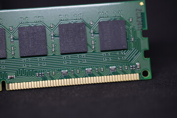 Computer memory module, close-up view of RAM, green circuit board design with chips, technology component on black background.