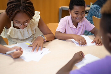 Naklejka premium Afro young diverse students collaborating on tasks during an educational activity