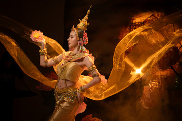 A beautiful woman in traditional Thai costume performing a classical dance