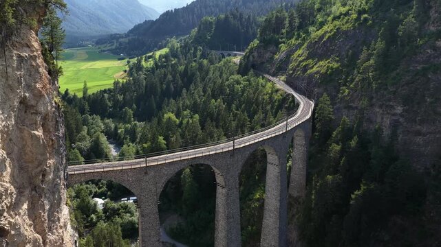 Aerial view of red train crossing the landwasser viaduct in switzerland