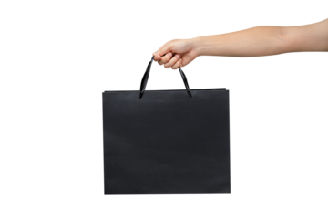 A person's hand holding a paper shopping bag with handles on a clean white background. Studio shot with ample copy space for text, logos, or branding. Isolated on white, cut out.