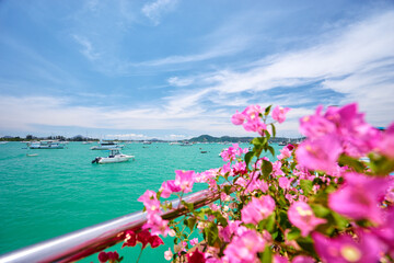 Obraz premium Scenic View of a Harbor with Flowers and Sailboats Under Blue Sky