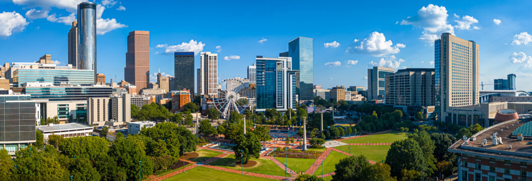 Daytime aerial view of downtown Atlanta skyline with parks, buildings, and clear skies