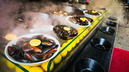 A local taste steamed stuffed mussels with rice are served with lemon slices at a Turkish street food stand