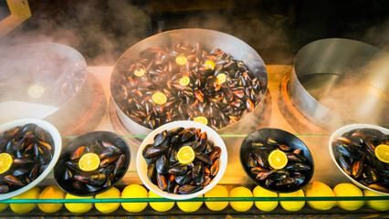 A local taste steamed stuffed mussels with rice are served with lemon slices at a Turkish street food stand