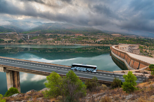 Granada, Spain, 9,20, 2025: Luxury Alsa Supra bus driving on a viaduct over the Rules reservoir