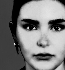 Face of a beautiful young woman in closeup in black and white monochrome with halftone effect