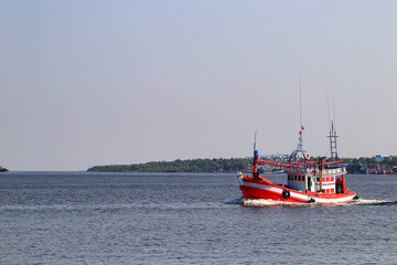 Fototapeta premium fishing, catching squid boat go to ocean background with transportation ship in Southeast Asia region.