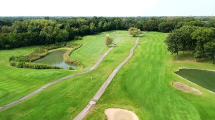 Drone view of golf course and players with the golf carts on it. Active pastime. Type of sport for rich people