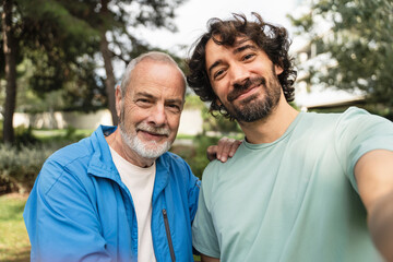 Senior Father and son taking selfie with mobile phone after doing sport together