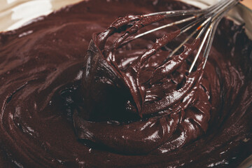 a bowl of chocolate dough, a whisk for whipping, baking, structure and consistency, homemade, top view, no people,