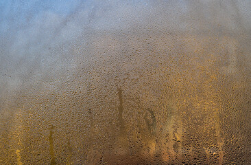 Close-up of water droplets on foggy window, showing texture of wet glass.