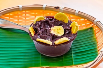 The most authentic Brazilian açaí, Euterpe oleracea, with banana in a minimalist bowl and compatible environment. Superfood energy and vitamins