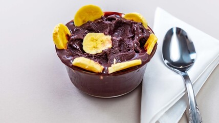 The most authentic Brazilian açaí, Euterpe oleracea, with banana in a minimalist bowl and compatible environment. Superfood energy and vitamins