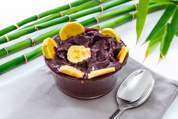 The most authentic Brazilian açaí, Euterpe oleracea, with banana in a minimalist bowl and compatible environment. Superfood energy and vitamins