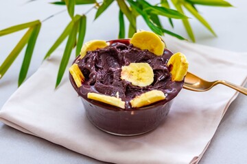 The most authentic Brazilian açaí, Euterpe oleracea, with banana in a minimalist bowl and compatible environment. Superfood energy and vitamins