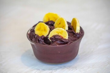 The most authentic Brazilian açaí, Euterpe oleracea, with banana in a minimalist bowl and compatible environment. Superfood energy and vitamins