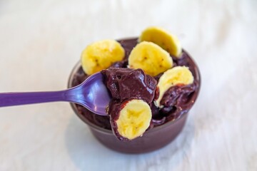The most authentic Brazilian açaí, Euterpe oleracea, with banana in a minimalist bowl and compatible environment. Superfood energy and vitamins