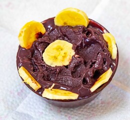 The most authentic Brazilian açaí, Euterpe oleracea, with banana in a minimalist bowl and compatible environment. Superfood energy and vitamins