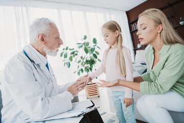 Obraz premium A warm home moment with a doctor visiting a mom and daughter in a cozy living room showing care and family bonds