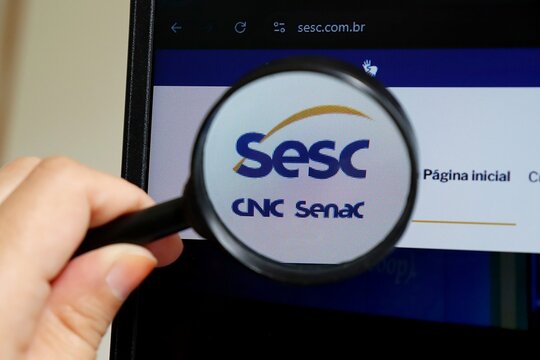 Salvador, Brazil - October 4th, 2025: SESC logo and a magnifying glass. SESC ( Servi&ccedil;o Social do Com&eacute;rcio) is a non-profit Brazilian private institution. 