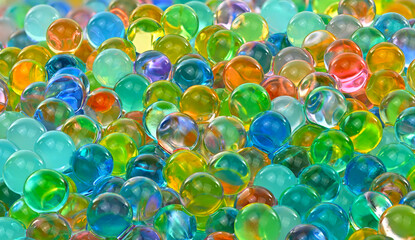 A bunch of colorful marbles are scattered on a surface