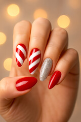 Close-up of stylish manicure featuring red and white candy cane striped nails, silver glitter accent nail, and glossy red tips. Ideal for Christmas, holidays, fashion, beauty, and lifestyle campaigns.