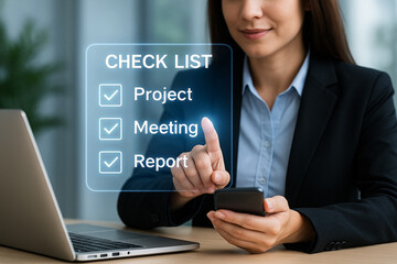 Businesswoman using futuristic digital interface with a virtual checklist for project, meeting, and report tasks while working with laptop and smartphone in modern office environment.