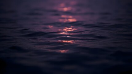 Gentle waves catch the faint light, creating shimmering patterns. The water seems to reflect the dusk sky.