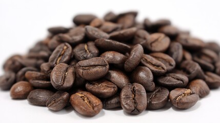 Naklejka premium A pile of coffee beans on a white background. The beans are of different sizes and are spread out in a random manner. Concept of abundance and variety