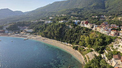 Aerial view of Parga Greece coastline with Valtos Beach, Ionian Sea, green forest hills and colorful houses. Scenic Mediterranean landscape and famous summer holiday destination.