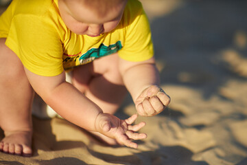Fototapeta premium Toddler enjoys sand play by the sea