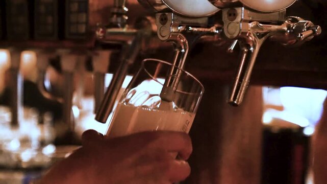 Nahaufnahme eines Zapfhahns, aus dem frisches Bier in ein Glas gezapft wird. Das Video vermittelt authentische bayerische Bierkultur und eignet sich perfekt f&uuml;r Themen wie Oktoberfest und Biergarten.