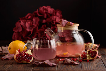 Autumn Beverage: Pomegranate Tea with Lemon and Ginger on Rustic Table