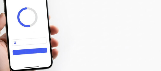 Hand holding smartphone with login screen including blue progress circle during account creation or data processing. Online security concept.