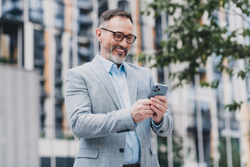 Confident businessman in a modern city wearing a suit uses a smartphone outdoors in a stylish urban office vibe that conveys professionalism and success © deagreez