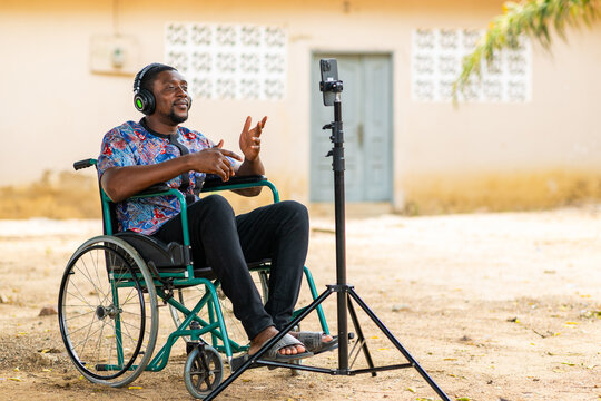 African Man in Wheelchair Using Smartphone for Video Call