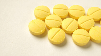Yellow tablets on white background.