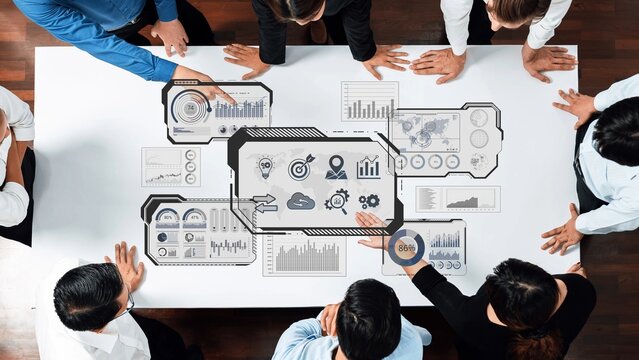 A diverse business team collaborates in a modern meeting space, focused on digital analytics and visual data representations during a strategy session. Raster