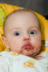 Baby Girl Eating in a High Chair