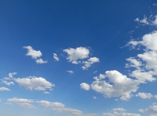 Obraz premium small cumulus clouds move across the clear blue sky.