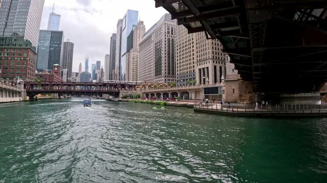 Low angle view from a tour boat sailing underneath the Franklin Street Bridge on the Chicago River in Chicago, Illinois. Spectacular skyline views on a Summer day in the city.