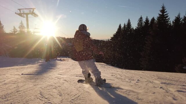 Female Snowboarder Descends Snowy Slope at Sunset in Kopaonik, Serbia