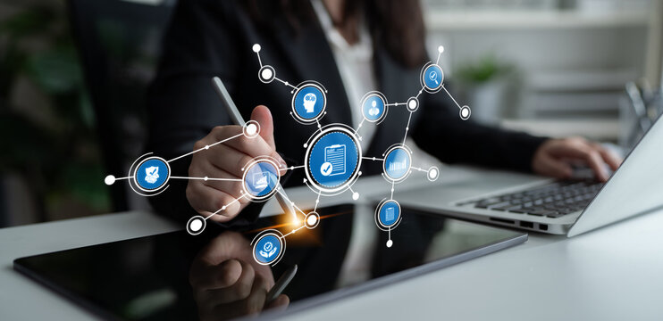 A businesswoman actively engages with a digital interface on a tablet. The image showcases the integration of technology and teamwork to enhance productivity. Tessel - Powered by Adobe